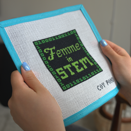 Femme in STEM Code needlepoint kit - stitched canvas detail showing green binary code design on black background