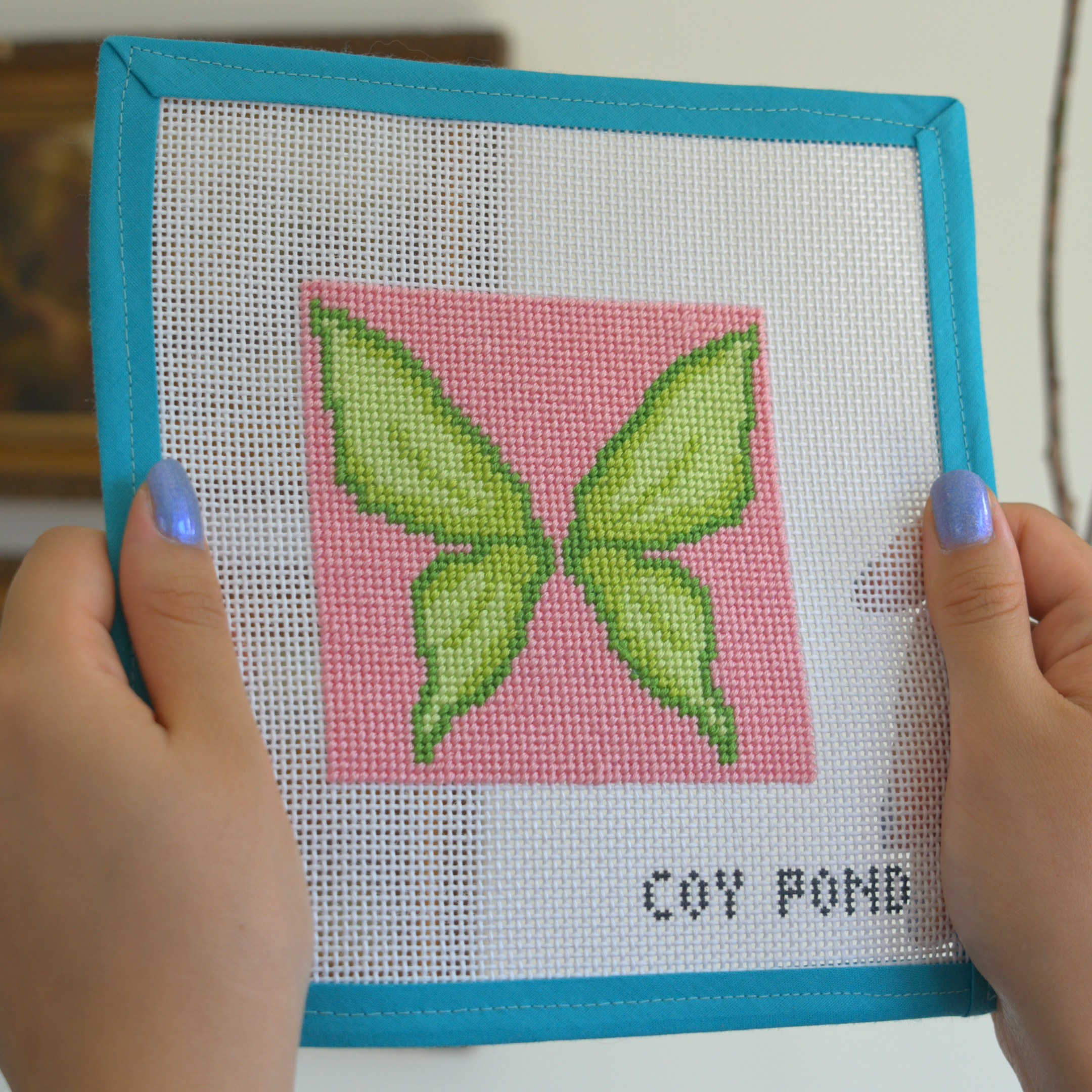Romantasy Fairy Wings needlepoint kit - completed stitched canvas showing green butterfly-shaped fairy wings on pink background